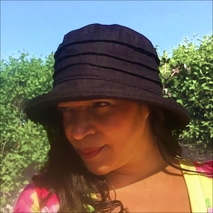 Puede incluir: Un sombrero de sol negro de ala ancha con una corona plisada. El sombrero est&aacute; hecho de una tela suave y ligera y tiene un ala ancha que proporciona una amplia sombra del sol.