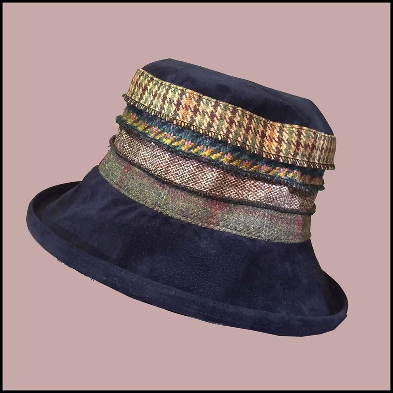May include: A navy blue velvet hat with a wide brim and a multi-colored patterned trim. The trim is made of different fabrics, including tweed and houndstooth.