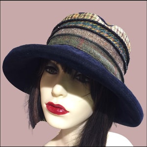 May include: A wide-brimmed hat with a navy blue velvet crown and a multi-colored patterned brim. The brim is made of a tweed fabric with a variety of colors and textures.