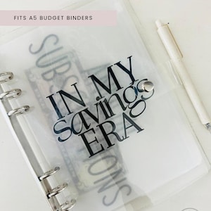 May include: Clear plastic A5 budget binder with a black vinyl insert that says "In My Savings Era".