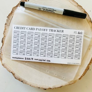 May include: A white credit card payoff tracker with black lines and a black &pound;10 sign. The tracker has 60 credit card slots. The text "Starting Balance: &pound;500.00 Card: capital one" is printed at the bottom of the tracker.