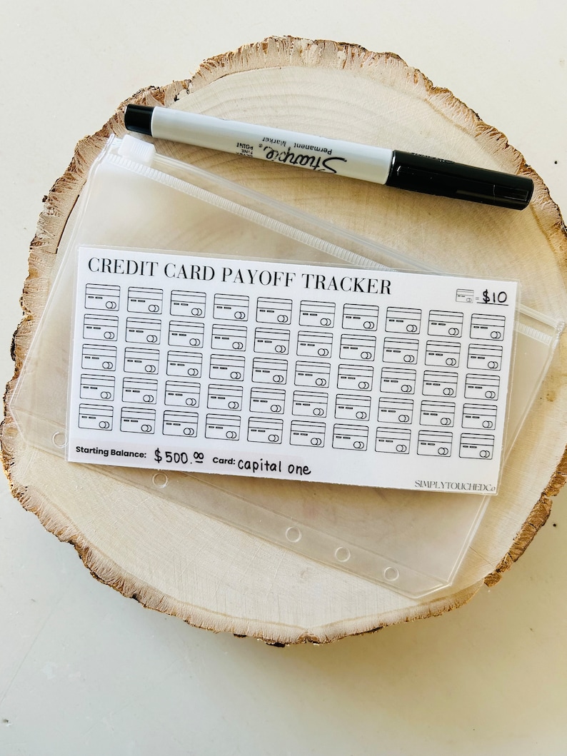 May include: A white credit card payoff tracker with black lines and a black &pound;10 sign. The tracker has 60 credit card slots. The text "Starting Balance: &pound;500.00 Card: capital one" is printed at the bottom of the tracker.