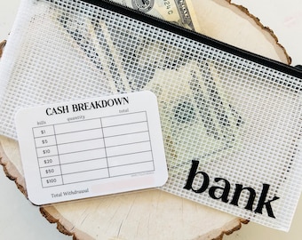 Puede incluir: Una bolsa con cremallera de malla transparente con una cremallera negra y la palabra "bank" impresa en negro. Un billete de veinte dólares es visible dentro de la bolsa. Una tarjeta de desglose de efectivo está al lado de la bolsa.