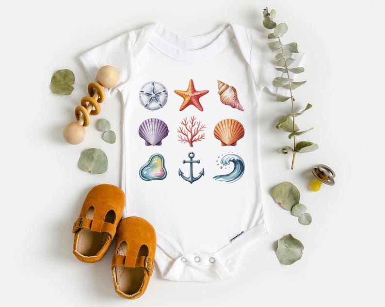 May include: White baby bodysuit featuring colorful watercolor illustrations of seashells, a starfish, coral, an anchor, and a wave. The bodysuit is surrounded by baby shoes, a wooden rattle, and decorative leaves.