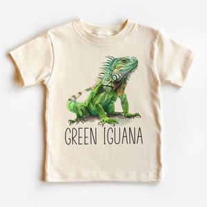 May include: A light beige t-shirt with a green iguana illustration and the text "GREEN IGUANA" printed on the front.