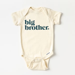May include: A cream-colored baby onesie with short sleeves and the text "big brother" printed in dark teal.
