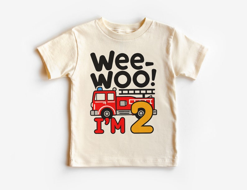 May include: A white t-shirt with a red fire truck and the text "Wee-Woo! I'm 2" in black and yellow.