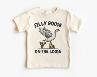 May include: A white t-shirt featuring a graphic of a goose wearing roller skates. The text "Silly Goose on the Loose" is printed on the shirt.