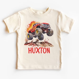 May include: A white t-shirt with a red monster truck graphic and the name "HUXTON" printed in red.
