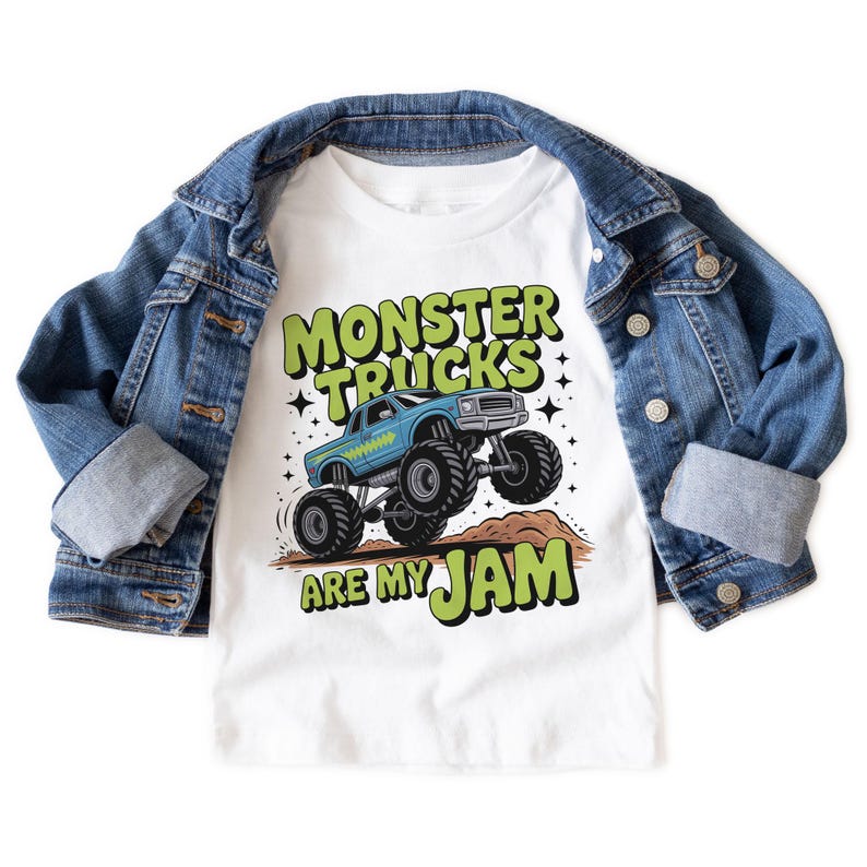 Puede incluir: Camiseta blanca con un gr&aacute;fico de cami&oacute;n monstruo azul y el texto "MONSTER TRUCKS ARE MY JAM" en verde y negro. Una chaqueta vaquera azul est&aacute; sobre la camiseta.