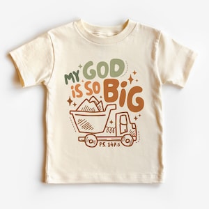 Op de afbeelding: Een wit T-shirt met een bruine, groene en oranje afbeelding van een kipper met de tekst "My God is so Big" en "PS. 147:5".