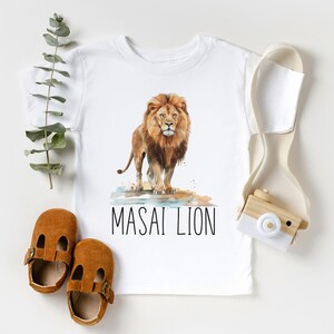 May include: White t-shirt with a watercolor illustration of a lion and the text "MASAI LION".