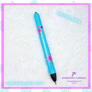 May include: A turquoise glitter pen featuring pink flamingo motifs. The pen is labelled "Refillable" and "Personalized Gift". The pen has a black tip and is set against a white background with a pink border.