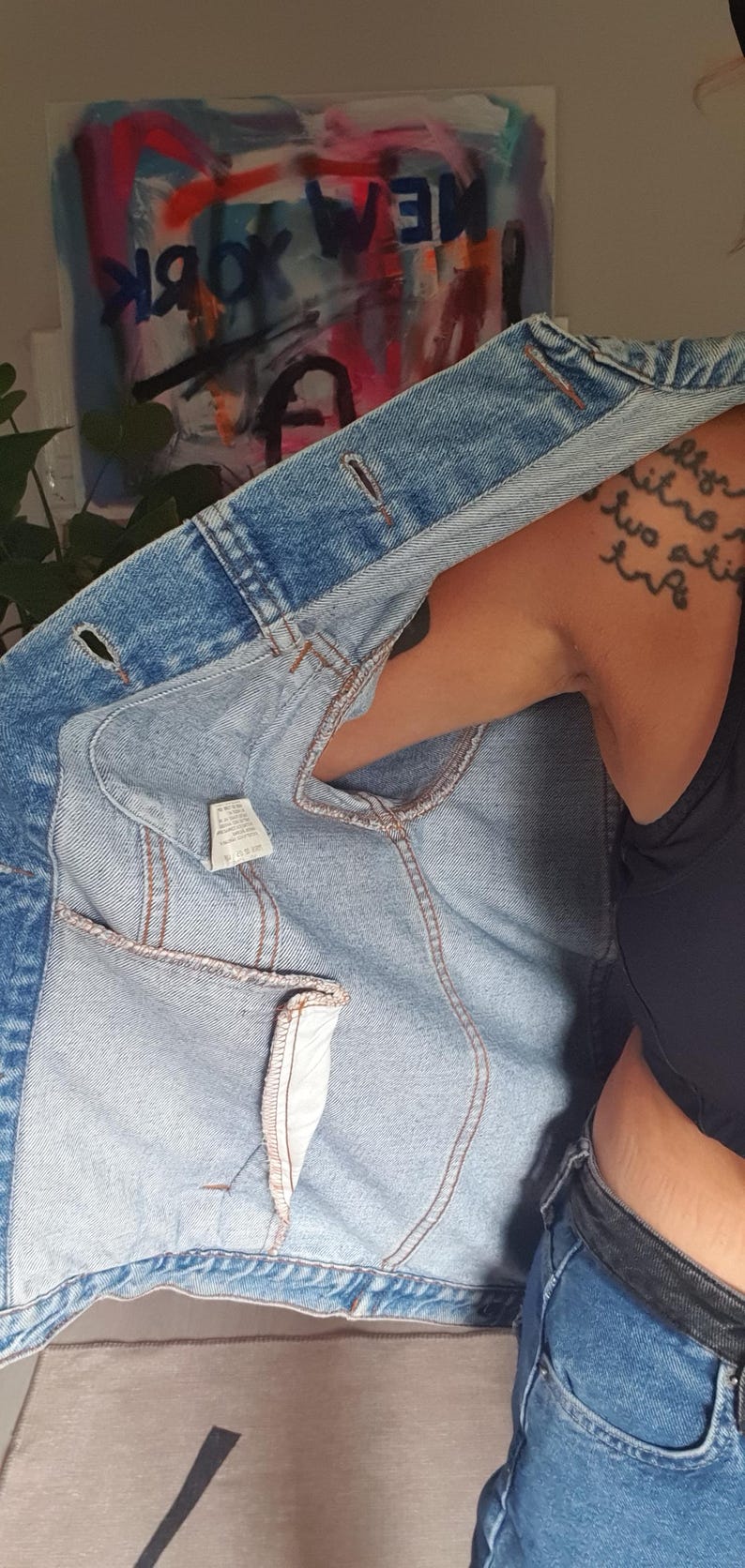 May include: A light blue denim jacket with a classic design. The jacket features a button-up front, pockets, and a light-wash denim fabric. The interior lining is visible, showing the stitching and construction details.