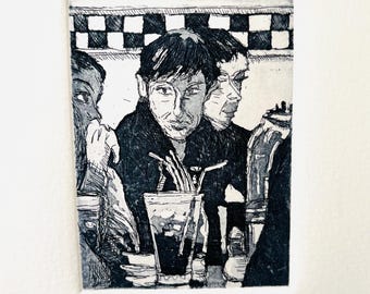 Könnte beinhalten: Schwarz-Weiß-Radierung mit dem Titel "Ed's Diner", die drei Personen an einer Theke zeigt. Im Hintergrund ist ein schwarz-weißes Schachbrettmuster zu sehen. Der Druck enthält ein Glas Soda mit Strohhalmen und eine Flasche. Der Druck ist mit 7/50 nummeriert.
