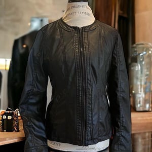 Veste de moto du début des années 2000. Simili cuir. Doublure en polyester. Super doux et confortable. Grande forme. Fermez la fermeture éclair. Pas d'étiquette. Femme M Il n'y a PAS D'ÉTIQUETTE