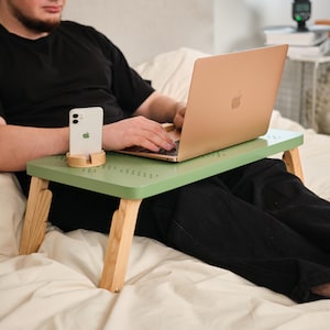 May include: A white ceramic mug with a black handle and the text "But First, Coffee" in a bold, black font. The mug is set against a blurred background, suggesting a cozy setting.