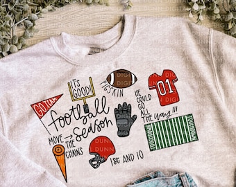 May include: A gray sweatshirt with a football theme. It features the text "Go Team", "It's Good!", "Pigskin", "He Could Go All The Way!!!", "Football Season", "Move The Chains", "Dun Dunn", "1st And 10", and "Touchdown".