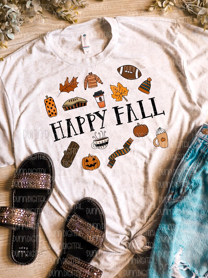 以下が含まれることがあります： 秋をテーマにしたアイコンと「HAPPY FALL」というテキストが描かれた白いTシャツ。アイコンには、かぼちゃ、コーヒーカップ、マフラー、フットボール、パイ、葉っぱ、セーター、丸太、帽子などが含まれています。