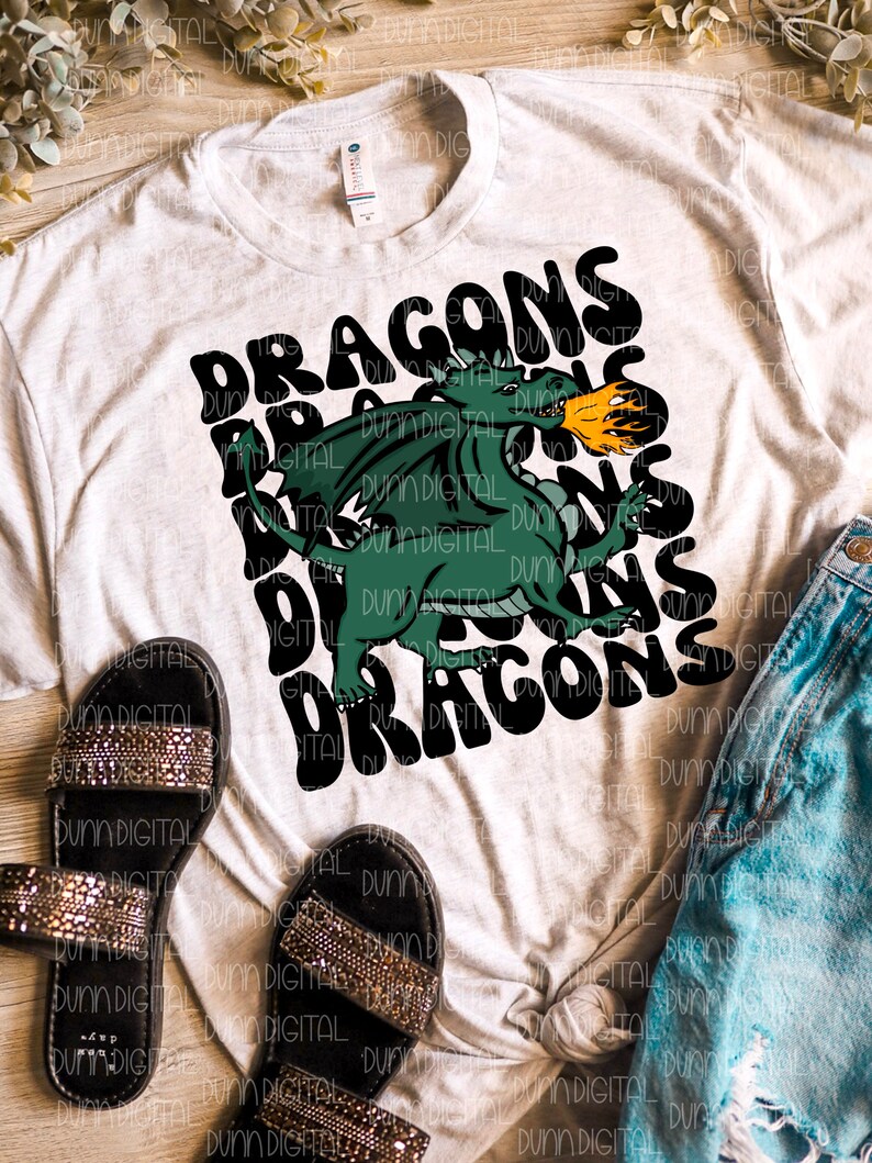 May include: A white t-shirt with a green dragon graphic and the text "DRAGONS" in black. The dragon is breathing fire and the text is in a retro font.