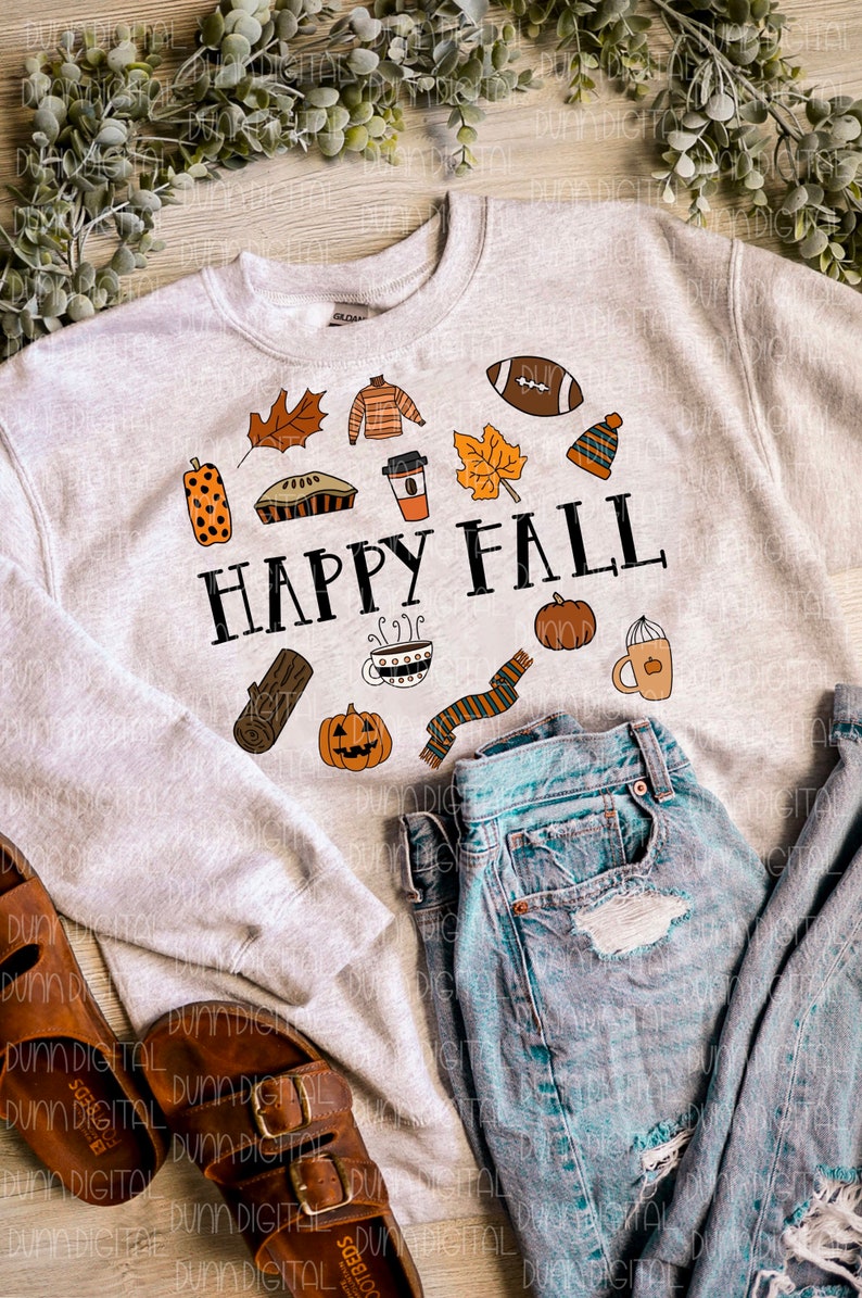 以下が含まれることがあります： グレーのトレーナーに、秋のテーマのアイコンと「HAPPY FALL」というテキストが描かれたグラフィックデザインが施されています。アイコンには、かぼちゃ、フットボール、コーヒーカップ、パイ、マフラー、丸太、葉っぱなどが含まれています。