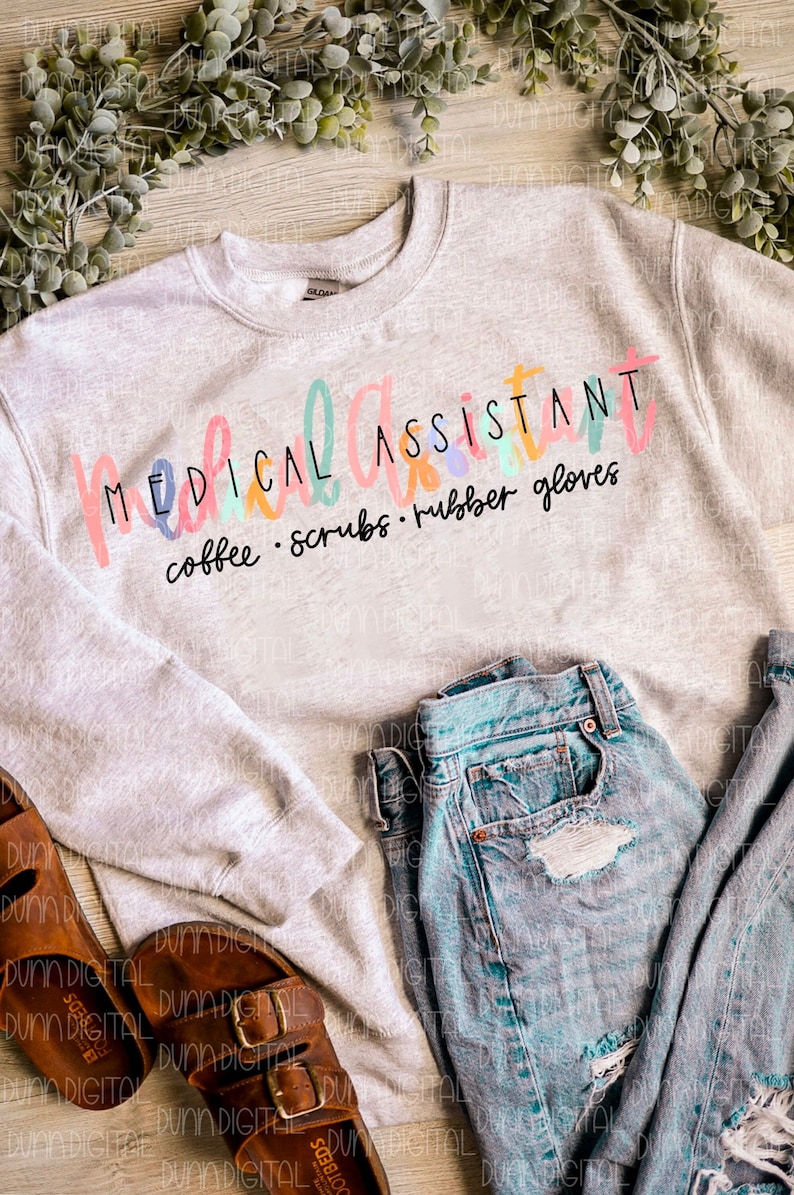 May include: A gray sweatshirt with the text "MEDICAL ASSISTANT coffee. scrubs. rubber gloves" in colorful lettering.