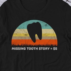 Pode incluir: Camiseta preta com um gráfico de pôr do sol retrô que apresenta uma silhueta de um dente. O texto "MISSING TOOTH STORY = 5€" é impresso abaixo do gráfico.