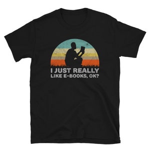 May include: Black t-shirt with a retro-style illustration of a person reading an e-book. The text reads "I just really like e-books, ok?"