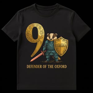 Pode incluir: Camiseta preta com um texugo de desenho animado em armadura segurando uma espada e um escudo. O escudo tem a palavra "COMMA". Um grande número dourado "9" e o texto "DEFENDER OF THE OXFORD" também estão na camiseta.