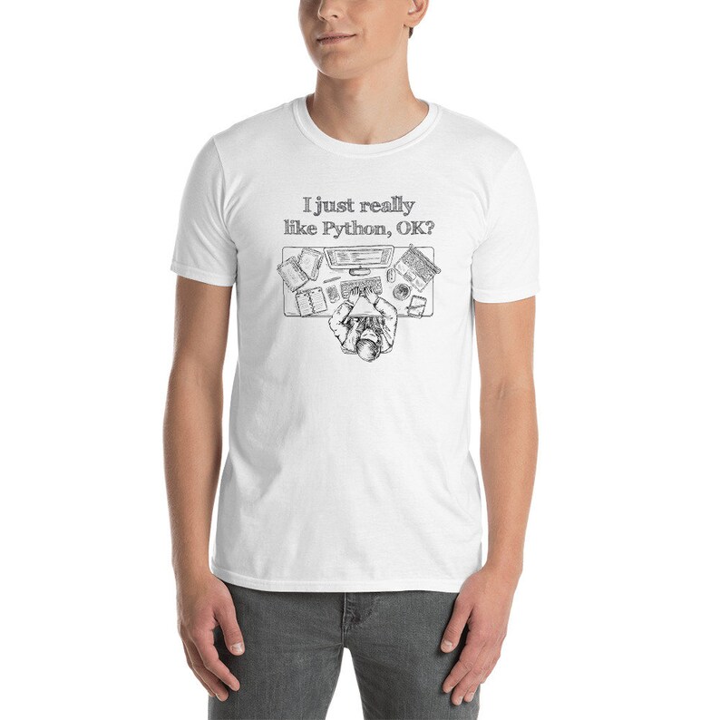 May include: White t-shirt with a black and white illustration of a person at a desk, typing on a keyboard. The text "I just really like Python, OK?" is above the illustration. The shirt is made of a soft material.