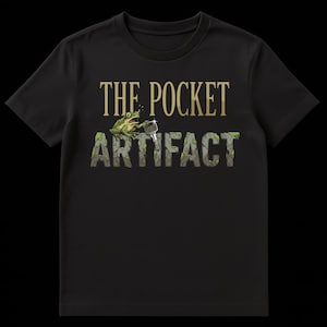 May include: Black t-shirt with the text "THE POCKET ARTIFACT" in gold and green. A cartoon frog is holding a small tool. The shirt is made of a soft material and has short sleeves.
