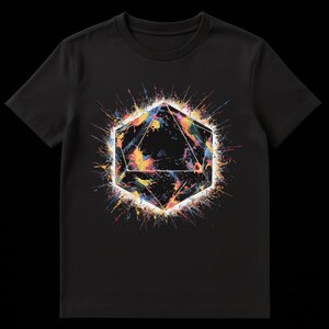 Op de afbeelding: Zwart T-shirt met een geometrisch ontwerp en kleurrijke verfspetters. De centrale vorm is een veelzijdig veelhoek met een witte omtrek, gevuld met gele, blauwe en oranje tinten.