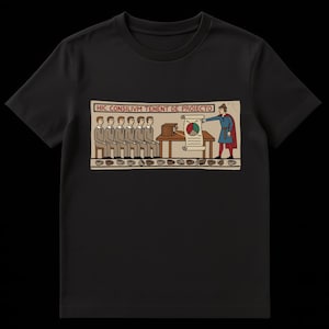 Pode incluir: T-shirt preta com uma ilustração colorida em estilo medieval. O design mostra figuras numa mesa, uma pessoa a apresentar um gráfico e o texto "HIC CONSILIVM TENENT DE PROIECTO".