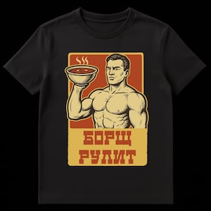 Peut inclure: T-shirt noir avec un dessin d'un homme musclé tenant un bol de soupe. Le graphisme comprend le texte "БОРЩ РУЛИТ" en jaune, sur un fond rouge et beige. Le bol de soupe dégage de la vapeur.