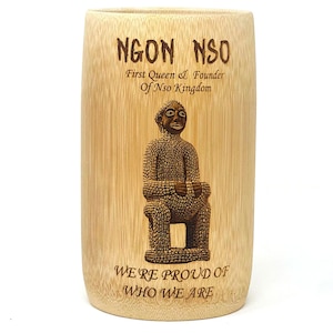 May include: A brown bamboo mug with a laser-engraved image of a seated figure and the text "NGON NSO First Queen & Founder Of Nso Kingdom WE'RE PROUD OF WHO WE ARE".