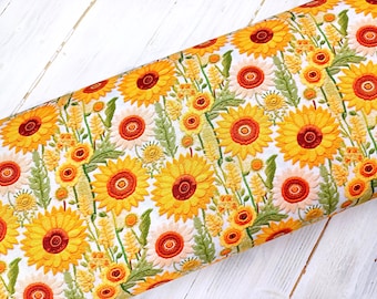 May include: White fabric with a repeating pattern of embroidered sunflowers in shades of yellow, orange, and green.