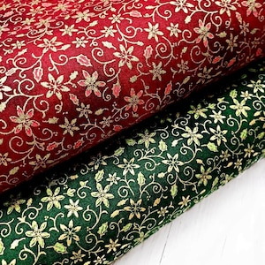 Pode incluir: Dois rolos de tecido, um vermelho e outro verde, com um padrão floral dourado repetido. O tecido vermelho tem uma cor profunda e rica, enquanto o tecido verde é de um tom mais escuro. O design floral inclui pequenas flores e espirais.