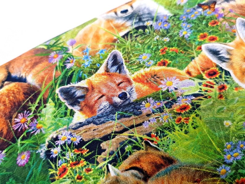 May include: A colorful fabric featuring a repeating pattern of foxes sleeping in a field of flowers. The foxes are orange, brown, and white, and the flowers are pink, purple, blue, and yellow.