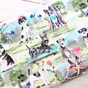 May include: Fabric with a whimsical print featuring various dog breeds in a park setting. Dogs are depicted wearing sunglasses, hats, and relaxing on beach chairs. The design includes flowers, trees, and a light blue and green color scheme.