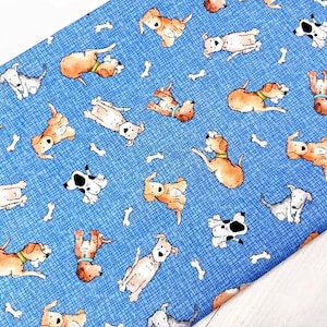 May include: Blue fabric featuring a repeating pattern of cartoon dogs in different poses, with scattered bone shapes. The dogs are in shades of brown, white, and black. The fabric has a textured design.