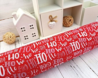 Könnte beinhalten: Roter und weißer Stoff mit einem sich wiederholenden Muster der Wörter "HO HO HO" in einem festlichen Weihnachtsdesign.