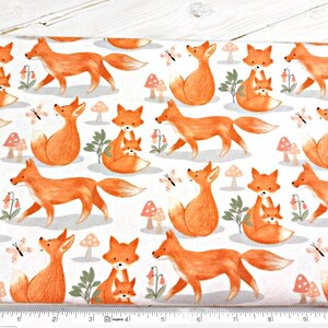 May include: White fabric with a repeating pattern of orange foxes. The foxes are in various poses, including walking, sitting, and holding a smaller fox. There are also small orange mushrooms and butterflies scattered throughout the fabric.