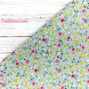May include: A light green fabric with a small pink and yellow floral print. The fabric is a sheer, lightweight material.