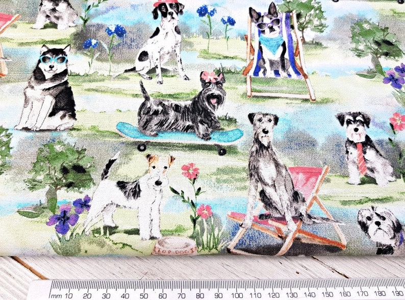 May include: Fabric with a whimsical print featuring various dog breeds in a park setting. Dogs are depicted wearing sunglasses, hats, and ties, some on skateboards or relaxing in beach chairs. The background includes flowers, trees, and a small dog bowl.