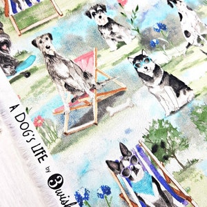 May include: Fabric with a whimsical print featuring dogs enjoying leisure activities. Dogs are depicted in sunglasses and beach chairs, with the text "A Dog's Life" visible. The background includes flowers and a blue sky.