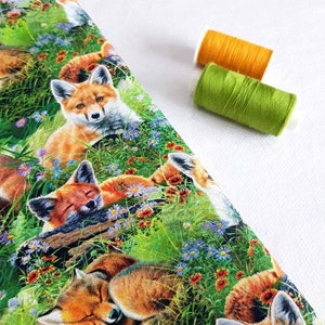 May include: A colorful fabric with a repeating pattern of red foxes sleeping in a field of green grass and wildflowers. The foxes are surrounded by blue, purple, and orange flowers.