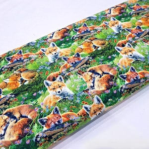 May include: A colorful fabric with a repeating pattern of sleeping foxes in a green grassy field with flowers. The foxes are brown and orange with white accents.