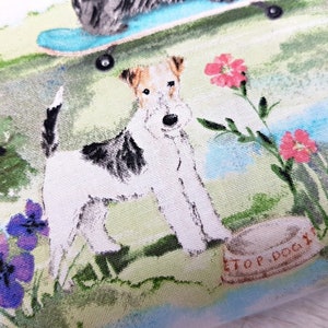 May include: Fabric with a dog-themed print. The design features a white and brown dog standing near a dog bowl with the text "TOP DOG". Other dogs are shown with a skateboard and flowers in a park setting. The color palette includes green, blue, and pink.
