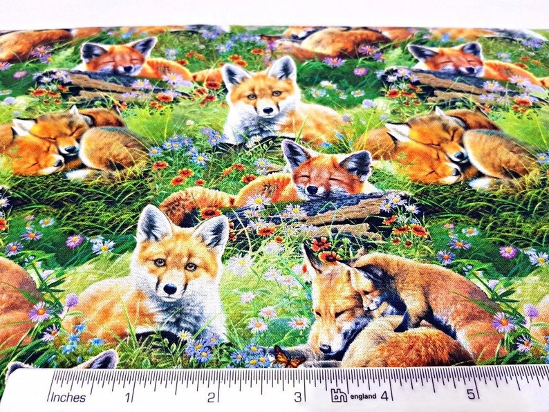 May include: A colorful fabric featuring a repeating pattern of red foxes in a grassy meadow with wildflowers. The foxes are in various poses, including sleeping, sitting, and standing.