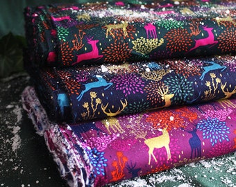 May include: Three pieces of fabric with a dark blue background and a repeating pattern of stylized reindeer and fireworks. The fabric is covered in a light dusting of white, resembling snow.